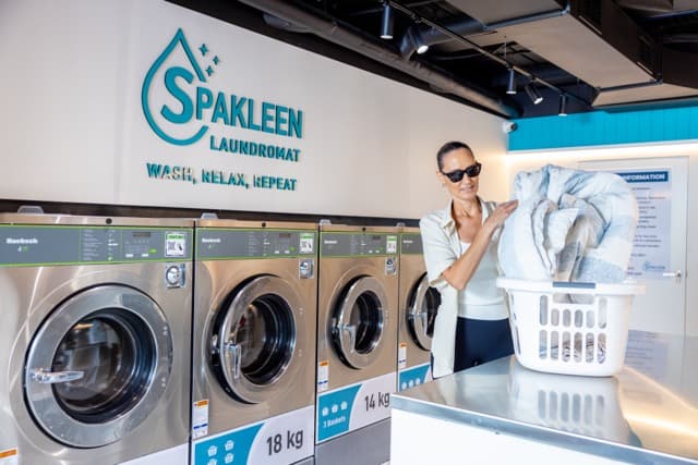 Customer folding bedding beside an 18kg Spakleen washing machine at the St Kilda store