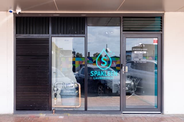 Entrance to the Spakleen Werribee laundromat with the Spakleen logo on the glass door