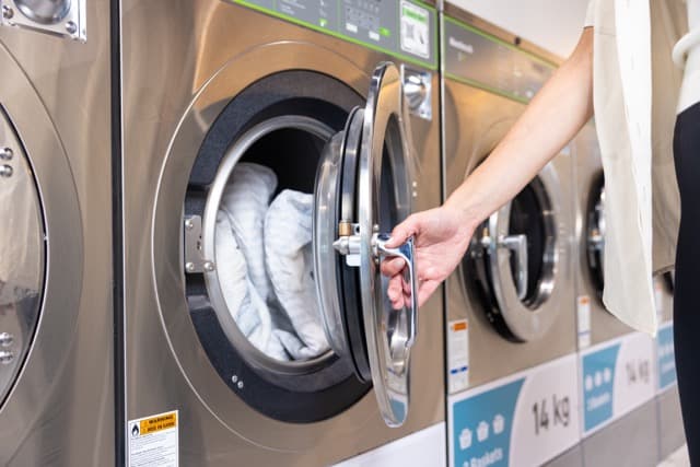 Bedding being loaded into a 14kg Spakleen washing machine